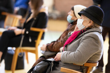 A group of elderly people wearing medical masks at a meeting or at a nursing home during a coronavirus epidemic.