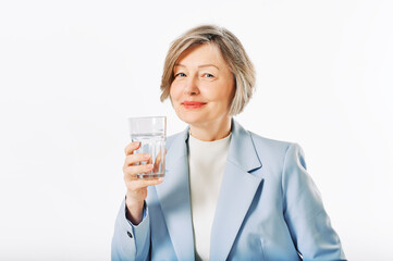 Studio portrait of middle age woman posing on white background, 55 - 60 year old female model holding glass of water