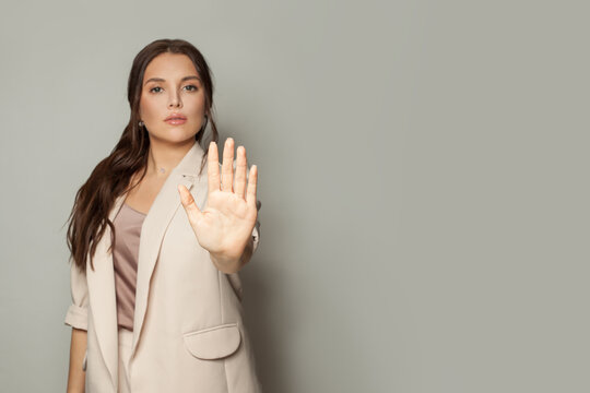 Clever business woman showing stop gesture on gray banner background