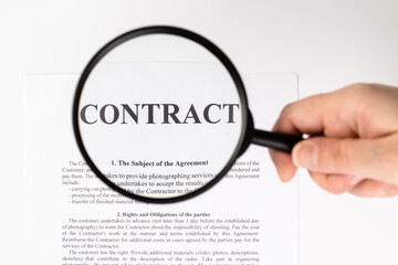 Businessman holding magnifying glass zoom and analyzing contract