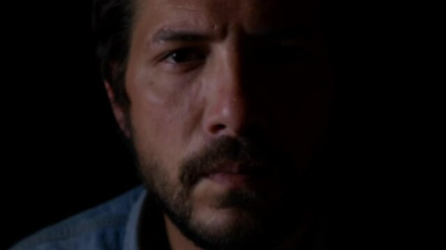 Face Of Bearded Man In Black Background Coming Close To The Camera From The Dark. close up, studio shot