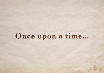 Close-up of "Once upon a time..." text on an old, stained and crumpled beige paper.