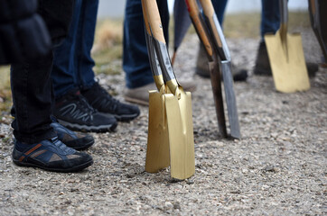 A golden spade at a groundbreaking ceremony for a building