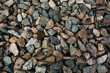 Old colorful stones rough background, many rocks near railway track close up