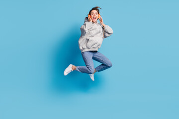 Fototapeta na wymiar Full length body size view of pretty cheerful crazy girl jumping listening hit having fun isolated over bright blue color background