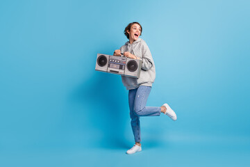 Photo portrait full body view of cute girl standing on one leg with boombox isolated on pastel blue colored background