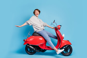 Obraz na płótnie Canvas Full length body size photo of funky girl sitting on retro motorbike laughing isolated bright blue color background