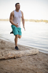 Sports man jogging and having training on the beach.