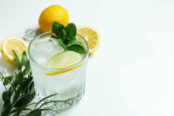 Glass of cocktail with lemon on white background