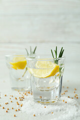 Shots of tequila on white textured table