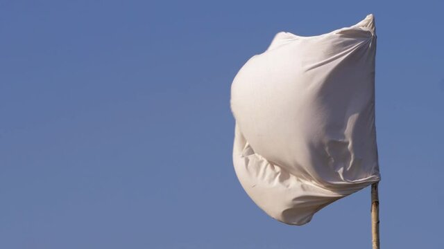 White flag of surrender blows in the wind