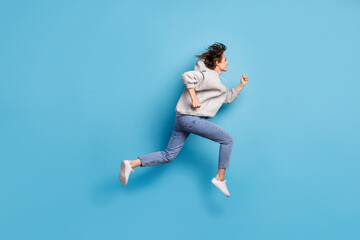 Full length body size side profile photo of girl jumping high running wearing sportswear isolated bright blue color background