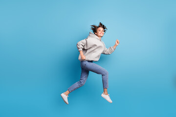 Fototapeta na wymiar Full length body size view of attractive energetic cheerful girl jumping running fast isolated bright blue color background