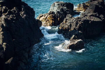 Blue foaming sea water hits the rocks