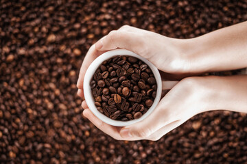 Coffee beans in hand. View from above