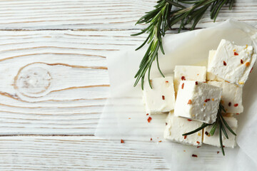 Feta cheese with spices and rosemary on white wooden background