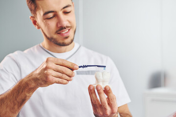 Portrait of professional dentist with equipment that standing indoors