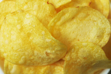 Tasty potato chips on whole background, close up