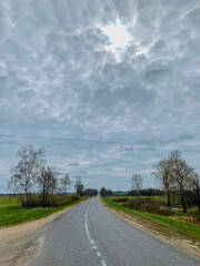 Empty country road on a cloudy day with thick clouds