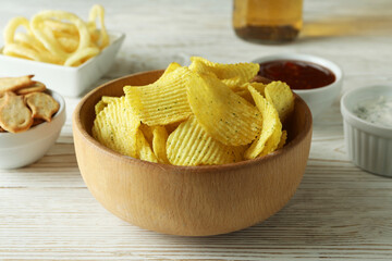 Different snacks, beer and sauces on white wooden background