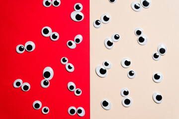 A bunch of toy eyes on an airtight two-color background split in half