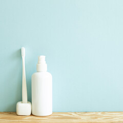 Skin care and spa concept. Bathroom bottle and toothbrush on wooden shelf. sky blue background