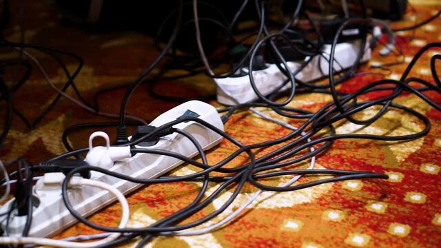 On the diagonal there is a white socket-splitter with a switch button with plugs from different devices and wires included in it