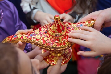 Golden Red Old magic lamp . They touch the old magic lamp with their hands .