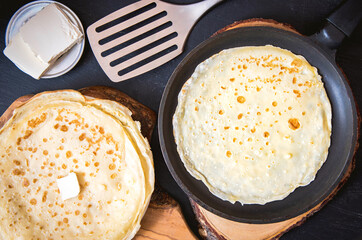 Pan with delicious thin Crepes on wooden board. Homemade thin pancakes
