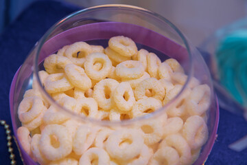 Round glass in the aquarium . Bowl of Whole Grain Cereal rings .