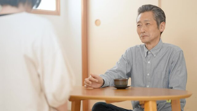 和室で会話をする若い女性とシニア男性