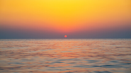 Obraz premium Colorful vibrant ocean beach sunrise during a summer day. beautiful sunrise
