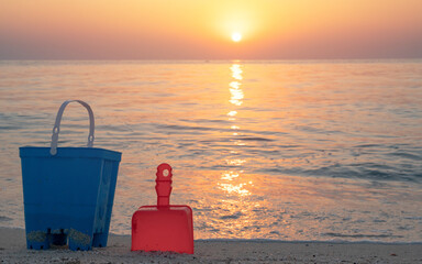 Children's beach toys - buckets, spade and shovel on sand on a sunny day