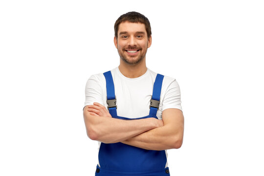 profession, construction and building concept - happy smiling male worker or builder in overall over grey background