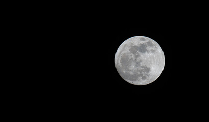 Full moon over dark black sky at night. Selective focus