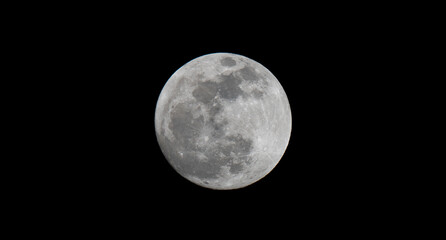 Full moon over dark black sky at night. Selective focus