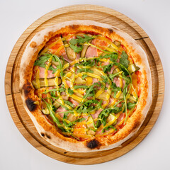 Top view of hot pizza on a wooden stand.