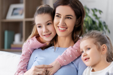 people, family and love concept - happy smiling mother with two daughters at home