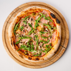 Top view of hot pizza on a wooden stand.