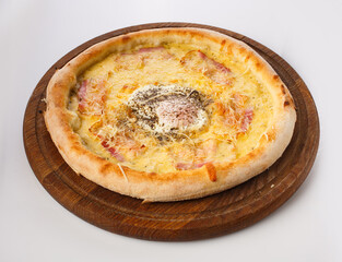 Top view of hot pizza on a wooden stand.