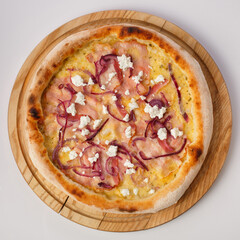 Top view of hot pizza on a wooden stand.