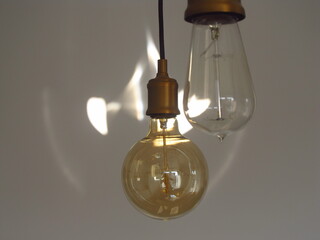 Stare lampy Edisona na tle białej ściny z blaskiem