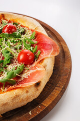 Top view of hot pizza on a wooden stand.