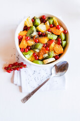 A bowl of fresh berry fruit salad on the white kitchen table. Vegan snack, diet food, healthy food concept.