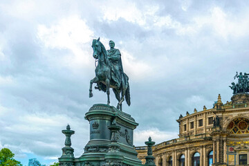 Fototapeta na wymiar Dresden, Germany - May 02 2019: statue of the Saxon King Johann at the facade of the Semper Opera, and the royal palace-residence, sculptor - Johannes Schilling, installed in 1889 on the Theaterplatz