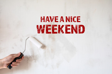 Have a nice Weekend. Paint roller in a man's hand. Concrete wall background