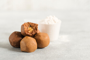 Healthy energy raw protein balls on light grey table. Fitness desserts, snacks.