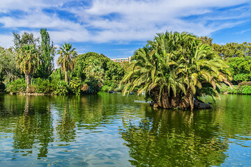 Fototapeta na wymiar Small lake in Park de la Ciutadella - popular spot where you can hire a rowing boat. Park de la Ciutadella - thirty-hectare large park close to always crowded historic center of Barcelona. Spain.