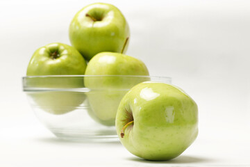 green apple and plate with apples on white isolated background