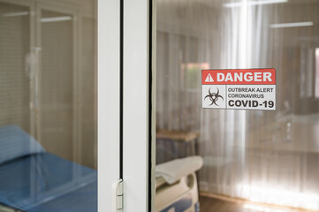 Sign in front of patient bed room door at quarantine zone area in hospital label Danger outbreak alert Coronavirus Covid-19.
